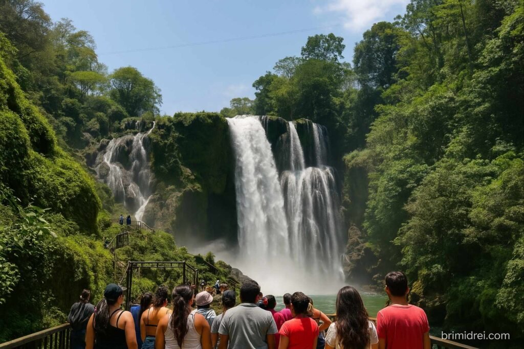 Tourists gathering on the observation deck in front of Pulhapanzak Waterfall in Honduras on a bright sunny day