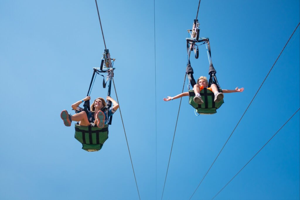 Adventurer soaring through the treetops on a zip line in Roatán’s lush jungle.